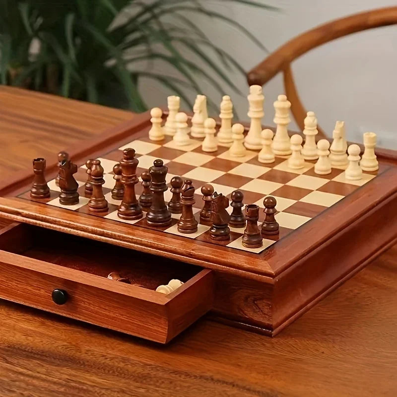 Échiquier en bois posé sur une table, pièces en place et tiroir entrouvert