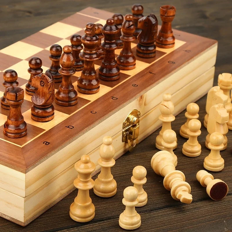 L'échiquier posé sur une table en bois, quelques pièces devant le coffret